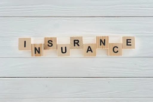 Word “INSURANCE” written on wooden tiles.