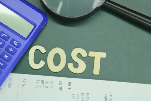 Word “COST” next to a calculator, receipt, and a magnifying glass.