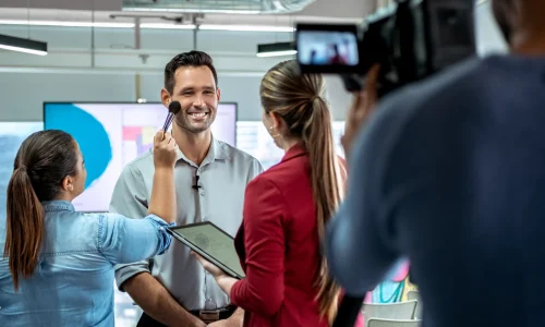 Managing payroll for your business can be a complex task, especially when balancing the needs of employees and contractors. - Two women interviewing a business man on camera