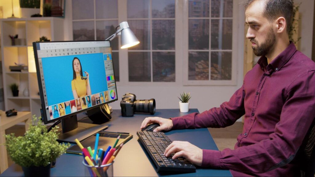 Freelance content creator retouching images in his home-based studio.