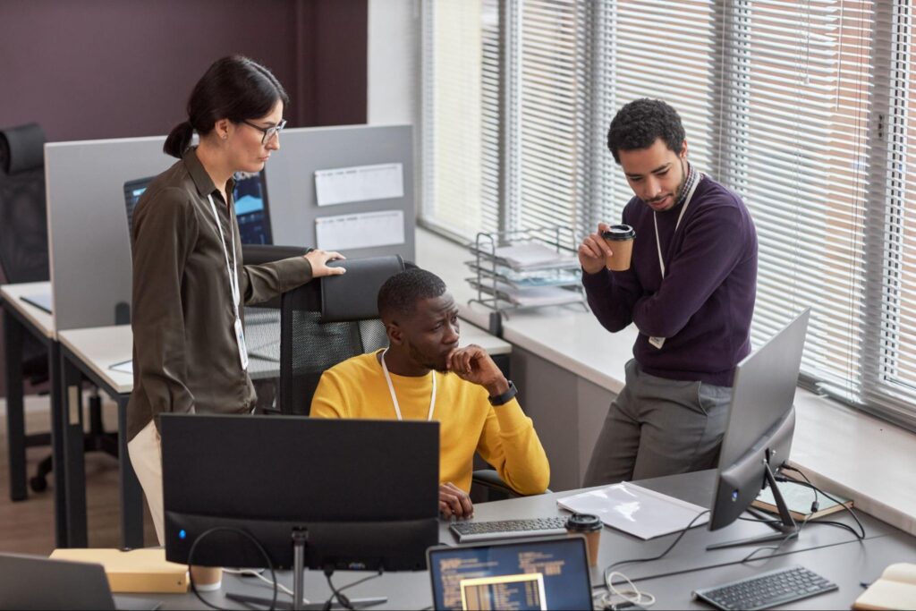 A team of IT professionals collaborate on software development in a modern office workspace