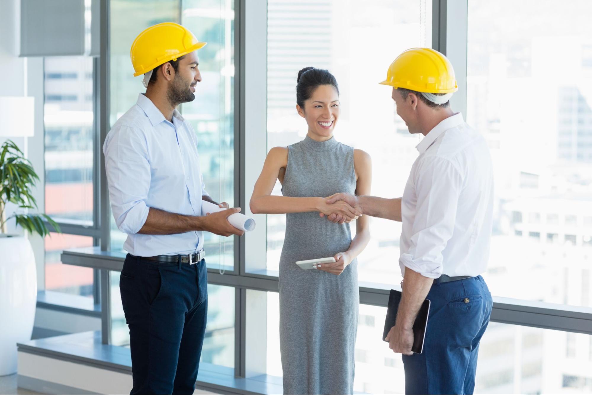 Client and architects finalizing a contract with a handshake, symbolizing trust and a liability insurance-backed agreement